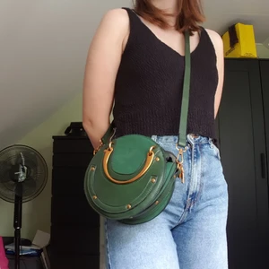 Grön rund väska. - Den unikaste väskan. Är grön memed guldiga detaljer. Går att ha över axeln som i bilden eller så kan man bära den med de guldiga handtagen. Som ny endast använd 1 gång.