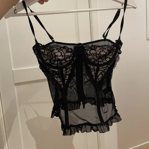 Svart korsett/topp - Svart topp med spets och dragkedja baktill. Passar från Xs-S. Passar kupa från A-C 