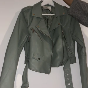 Kort grön skinnjacka - Jätte fin skinnjacka, älskar denna jacka men den kommer aldrig till andvändning och nu e den för liten för mig. Den är andvänd 1 gång så den e helt ny. Köpte den för 2-3 månader sen,