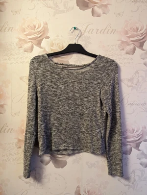 Tunn stickad tröja öppen rygg - Denna tunnstickade tröja är mjuk och stretching i matralaet med en halövven rygg. Bra skicka och normal i storleken.