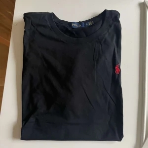 Polo T-shirt - Svart Polo Tshirt med röd logga Oanvänd, pris kan diskuteras!