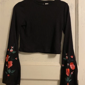 Långärmad croptop - Långärmad croptop med fina blommor på ärmarna. Bra skick. Strl S