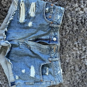 Jeansshorts från HM - Korta jeansshorts med slitningar från HM, storlek 40