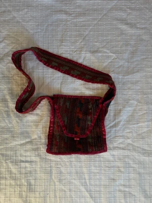 Färgglad väska - Har lite lösa trådar på vissa ställen då den är sydd på det sättet. Bredd längst ner 23,5cm. Längd 20cm. Djup 5cm. Frakt tillkommer 💕