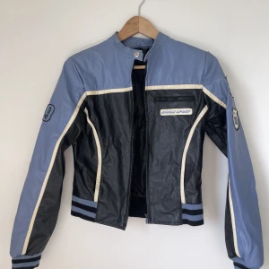 Racer jacket  - Jättesnygg jacka i fake skinn, biker/racer modell. Size 10 men skulle säga s/m mer. Liten spricka under ena armen och större spricka under andra, därav priset. Skriv för fler bilder på defekterna! 