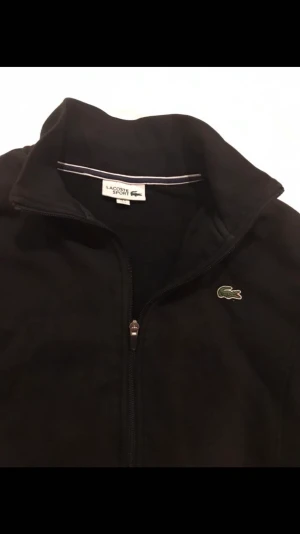 Lacoste zip  - Hej jag vill sälja min svarta Lacoste tröja cond:8/10 använd några gånger 