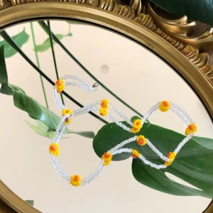 Pärlat halsband  - Pärlat halsband med söta små solrosor 