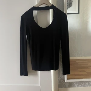 Ribbad topp - Ribbad topp med inbyggd choker och lättare v-ringning. Bra basic plagg att lätt kunna styla till fest look. Använt skick.