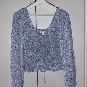 Blommig blus - Söt blus med blommor från H&M. Utmärkt skick, använd ca 1-2 gånger förra sommaren. Stor i storleken vid axlarna så kan även passa en M.