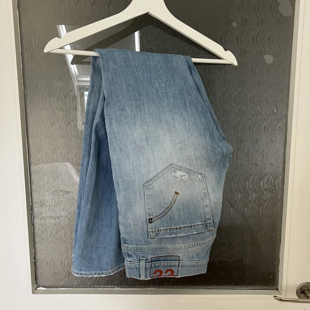 Ripped ljusblåa Dondup jeans i modellen George. Säljer då jag inte får någon användning för dem längre. Inte alls mycket använda och i väldigt bra skick. Köptes för något år sedan.. Jeans & Byxor.