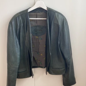 Läderjacka  - Skitcool mörkgrön vintage läderjacka från Creation Salman! Den har en knapp längst ner på framsidan. Uppskattar att storleken är M