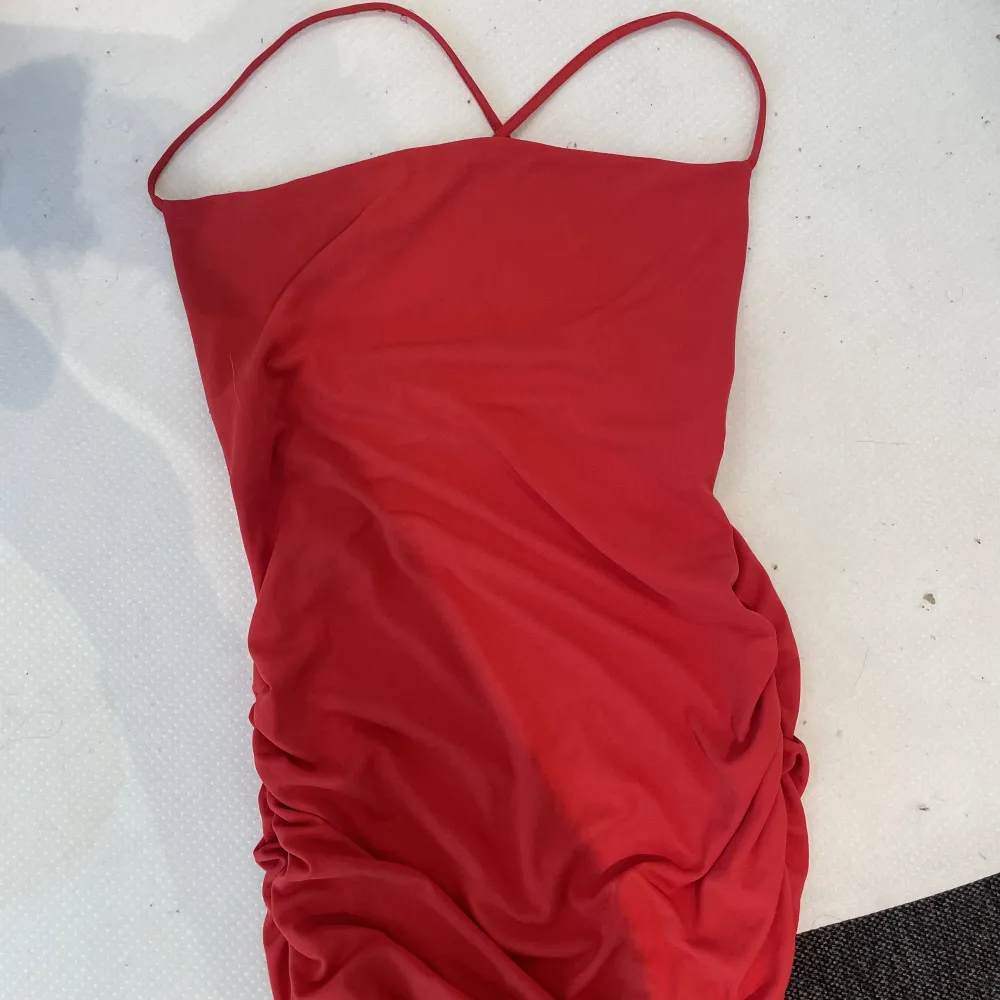 En röd klänning från zara i storlek S.  Sitter tajt mot kroppen och axelbanden korsar sig fint i ryggen. Använd 1 gång. Tvättas innan den skickas/hämtas . Klänningar.