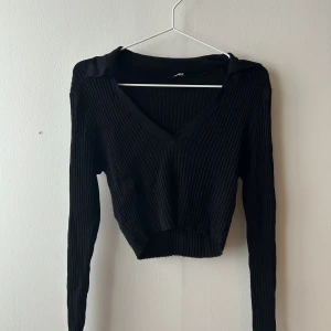HM top - En kort ribbad top med krage 