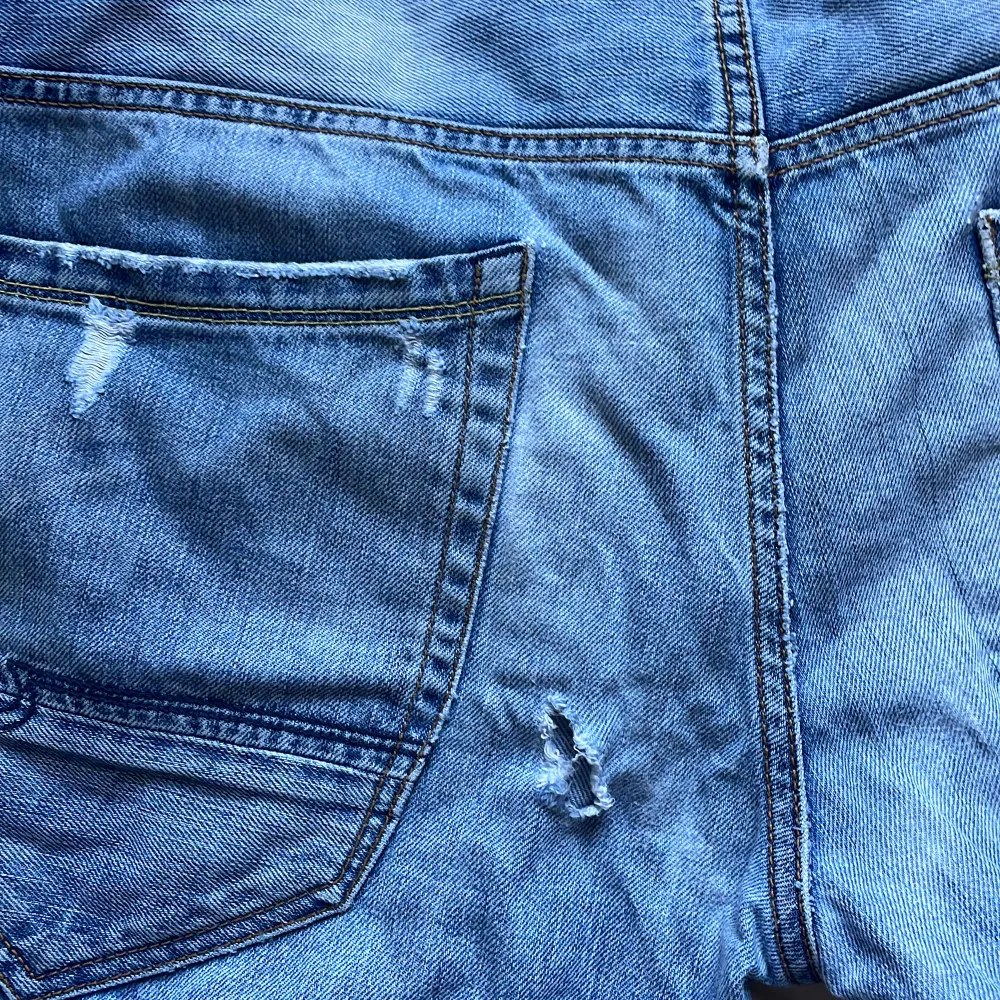 Slitna blå jeans med litet hål vid ena bakfickan, ganska små i storleken . Jeans & Byxor.