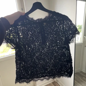 Topp  - Spetstopp i svart med en dragkedja där bak. Aldrig använd 