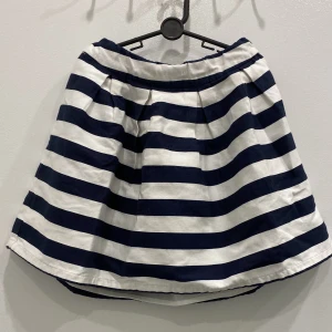 Randig kjol - Det är en randig kjol med färgerna vitt och marinblått. Den är inte använd och i bra skick.