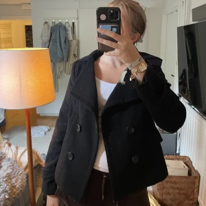 Svart kappa  - Snygg kort kappa i ull. Lite liknande designby si-kappan om man letar nått i den stilen! 