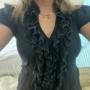 Svart blus med volang💕 - Säljer denna jättesöta blus med volang. Använd ett fåtal gånger inga defekter💗
