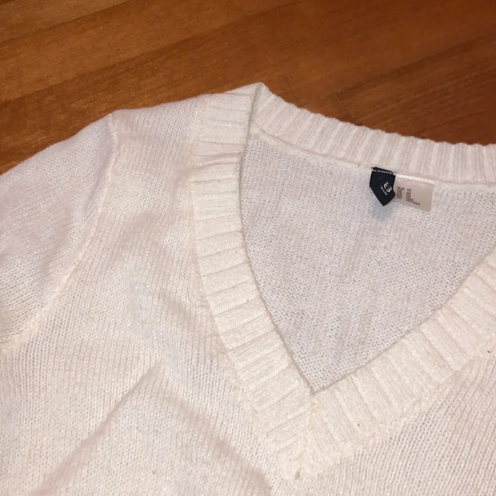 en vit tunn croppad stickad tröja med v-neck från hm❤️ köpt för ungefär 2 år sen och säljer för jag tycker att den är för kort och använder den aldirg. den har några små fläckar fast de syns inte så mycket. lite nopprig också. skriv för mer info/bilder❤️. Stickat.
