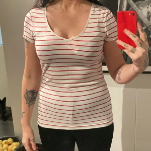 T-Shirt randig  - Fin t-Shirt med lätt v-ringning.  Strl. S. Jag på bilden är en strl. S-M. Väldigt stretchig. Använd men i fint skick.