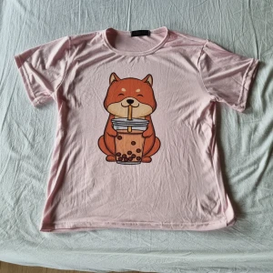 Söt rosa tshirt stl M - Rosa, gullig t-shirt med tryck av en shiba som dricker boba tea. Storlek M, från kawaii.se. Knappt använd.
