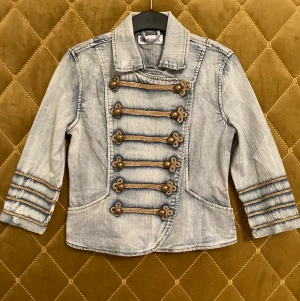 Kavaj, Flash - Kort Kavaj i stretchig jeans tyg från Flash. Strl 36, ljusblå med guld detaljer och trekvartslånga ärmar. Aldrig använd! Köparen står för frakt 