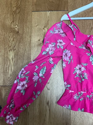 Rosa blommig tröja  - Rosa blommig tröja från HM. Fina detaljer och volanger. Lång ärmad. 