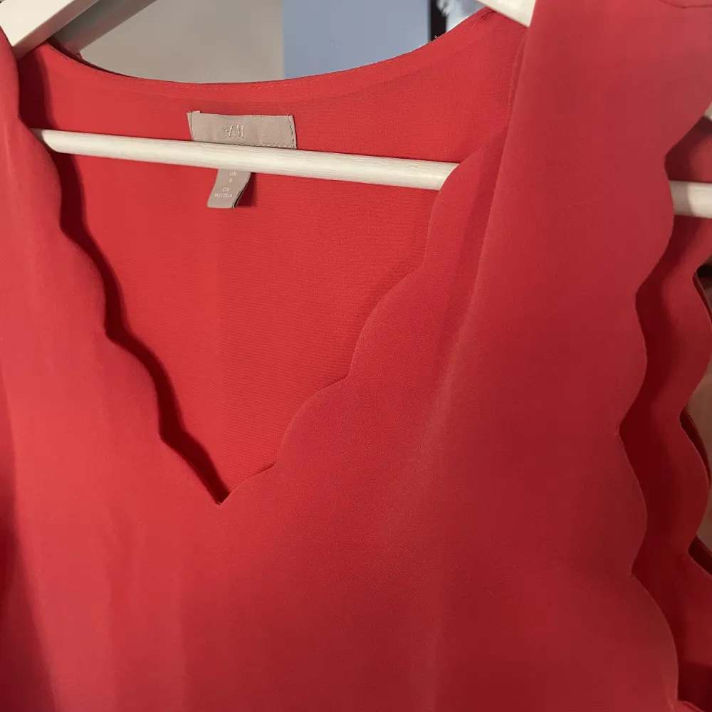 Supersött rött linne från H&M. Detaljer upptill vid armarna och halsen. Använt fåtal gånger . Toppar.