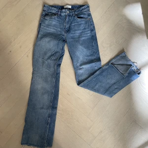Mango jenas - Midwaist Jeans från Mango i storlek 38, i väldigt bra skick. De har slitningar vid fötterna och en slits på insidan av benet. 