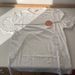 Santa cruz T-shirt - En feeet skate t-shirt med tryck på ryggen och framsidan. Trycket har dock börjat flagna lite med det trillar inte av. Jag använde den mycket innan jag växte ur den så nu vill jag bli av med den. Pris kan variera