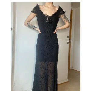 Killstar lång klänning - Lång klänning från killstar med mesh och snörning därfram samt lace på överdelen vid hålen även snörning på framsidan. denna kläningen är väldigt stretchig och passsr allt från XS till en liten M. Riktigt snygg med korsett eller med bälte