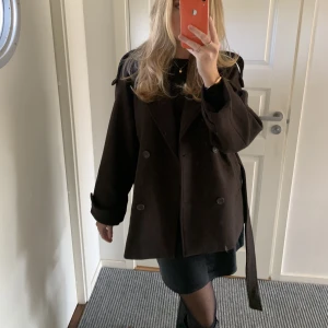 Brun kappa - Säljer denna sjuuukt snygga kappa från Moa Mattsons kollektion med NA-KD!!! Den är helt oanvänd och alla lappar finns kvar! Säljer eftersom jag beställde två storlekar💕