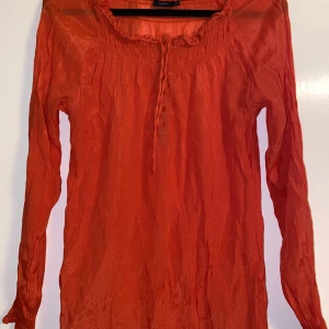 Blus - Ljusröd blus med knappar och störning framtill. Blusen är från Fransa i storlek L.