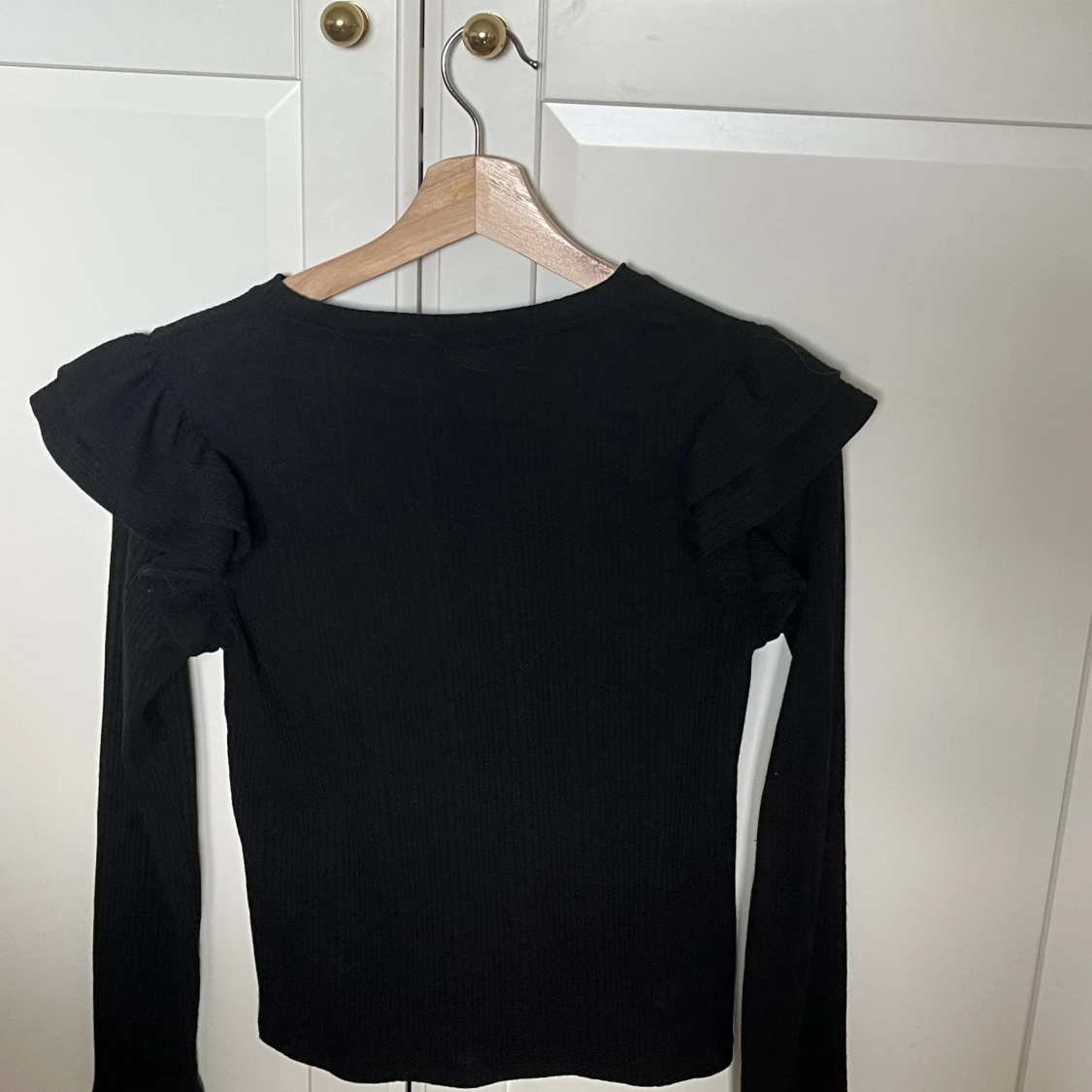 En svart ribbad tröja med volang - 90