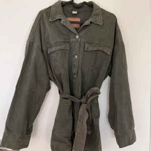 Jeansjacka  - Grön jeansjacka med ett band man kan knyta runt midjan från H&M. 