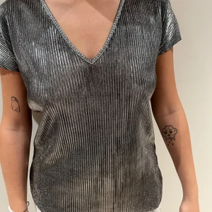 Silver Topp - Silver topp från NAKD i XS. Stor i storleken så passar absolut upp till L beroende på hur tajt man vill ha den. Super fin!🤍