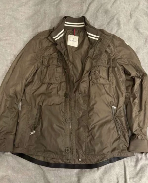 Moncler Field Jacket - Olivgrön Moncler Field Jacket storlek 4 i mycket fint skick.  Finns i Malmö eller fraktas.  2500kr eller bud