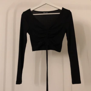 Svart ribbad topp - Ribbad topp från shein som går att tjustera längden på. Använd fåtal gånger.