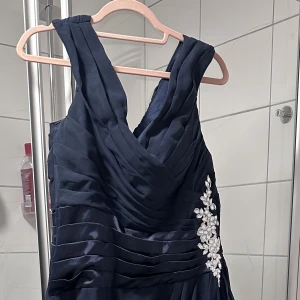 Marinblå fin aftonklänning - En fin marinblå aftonklänning, använt en gång.  Storlek cirka 44-46 men beställt för egna mätta   Mätt (ungefär): Bröst 96cm Midja 87cm Lång 156cm  Kemitvätt