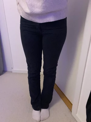 Svarta jeans  - Svarta lågmidjade jeans med en slits nertill vet inte storleken men skulle gissa typ 34/36 passar mig som är 165cm lång