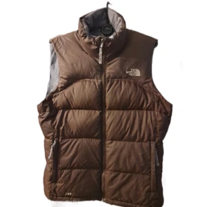 Vintage The North Face 700 väst - En brun vintage The North Face väst med vit logga. Den är riktigt bekväm och varm som en väst inför vintern. Storlek L. Lite mörkare fläck på kragen och en liten del av mitten-zippen är av, annars inga defekter. Dm för bild på det. Läs min b