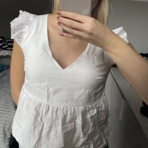 Söt vit topp - En vit topp med lite spets på axlarna, i en S men ganska liten i storleken!