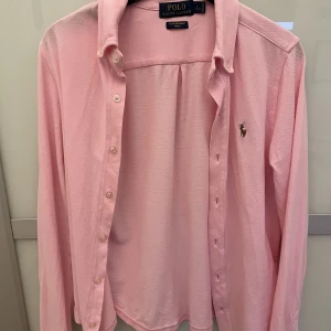 Polo Ralph Lauren skjorta  - Rosa polo Ralph Lauren skjorta i storlek ungdoms L (14-16 år). Motsvarar 170-176 Jätte finnt skick använd endast ert fåtal gånger. 