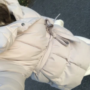 Beige varm vinterjacka - INTRESSEKOLL på denna supersöta vinterjacka. Den är väldigt varm och går att knäppa hela vägen samt har snörning i midjan vilket man kan ta bort om man vill. Kommer inte till användning🍂💞