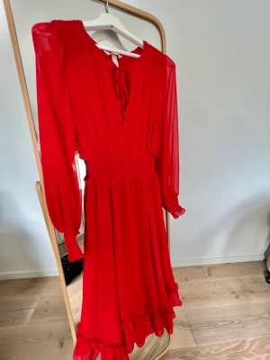 Röd klänning - Röd klänning med fina detaljer och storlek 34