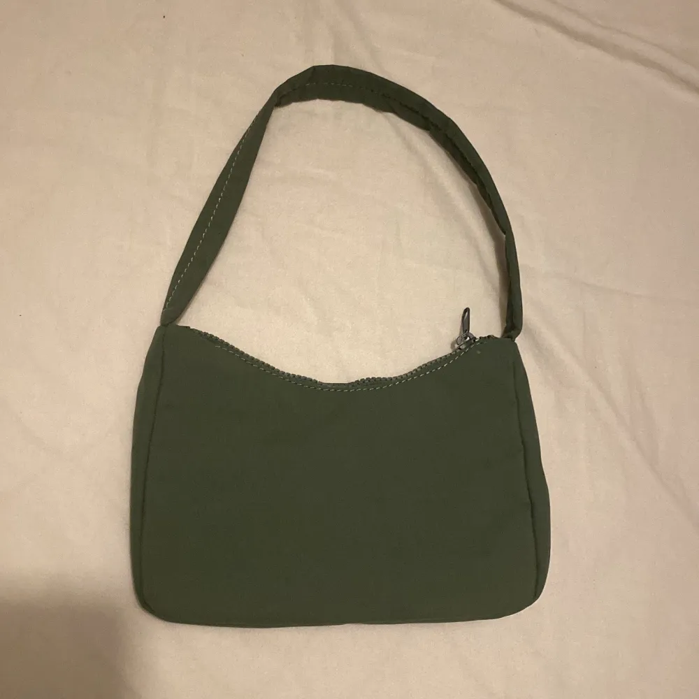 Säljer denna söta handväskan från Gina Tricot. Har ej reglerbar band. I fint skick. Färgen är grön. . Väskor.