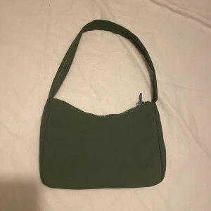 Väska från Gina Tricot  - Säljer denna söta handväskan från Gina Tricot. Har ej reglerbar band. I fint skick. Färgen är grön. 