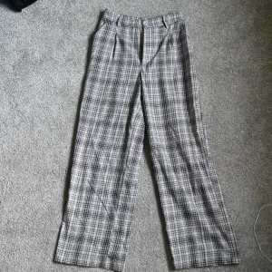 Kostymbyxor rutiga - Supersnygga och bekväma kostymbyxor i ett fint rosa-och grårutigt mönster. I storlek 38 från divided. 