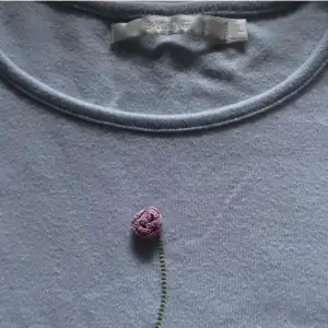 Ljusblå vintage T-shirt men en supersöt liten rosa ros på storlek L men liten i storleken