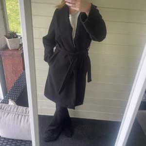 Säljer min svarta kappa som jag köpte förra hösten. Den har en liten slits baktill, 2 fickor och skärp.💕